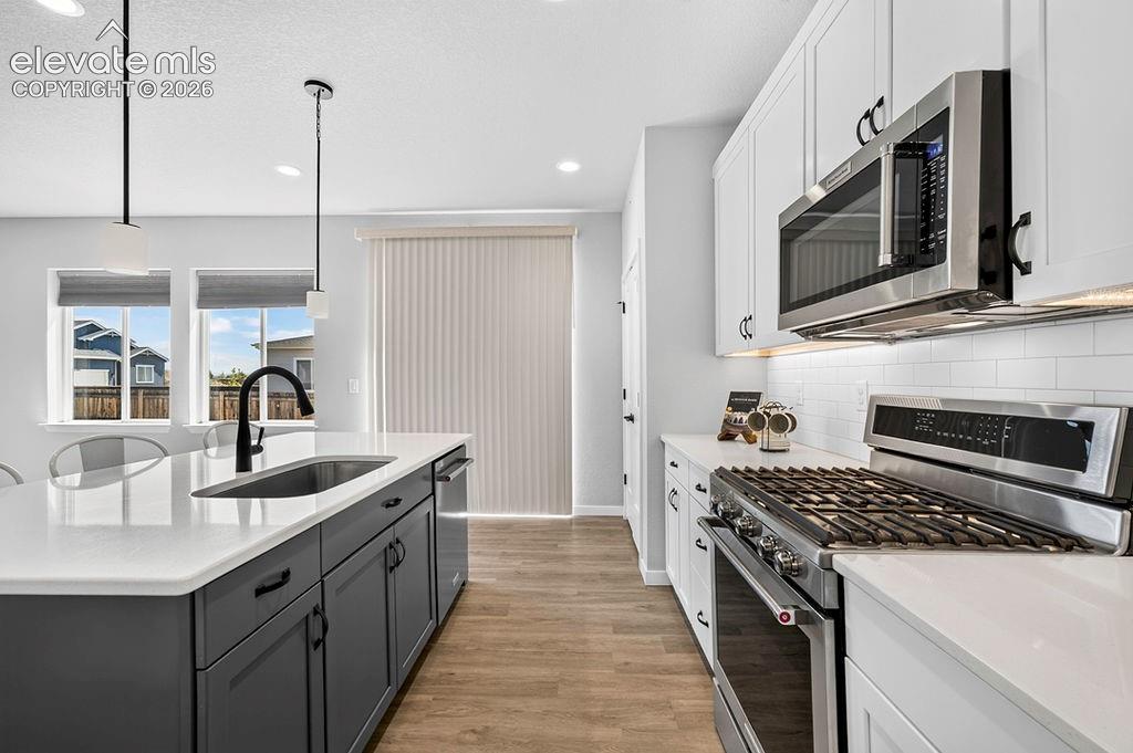 Image 17 of 47: Modern kitchen featuring a large island with an undermount sink and matte b