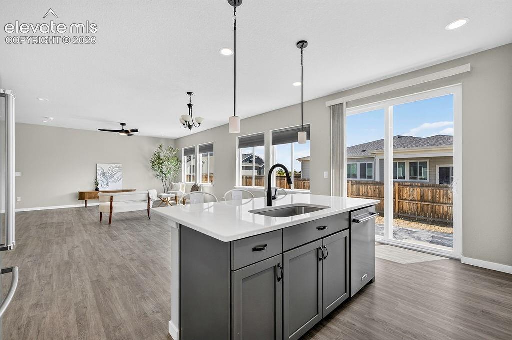 Image 19 of 47: Kitchen island with quartz countertop and undermount sink, complemented by