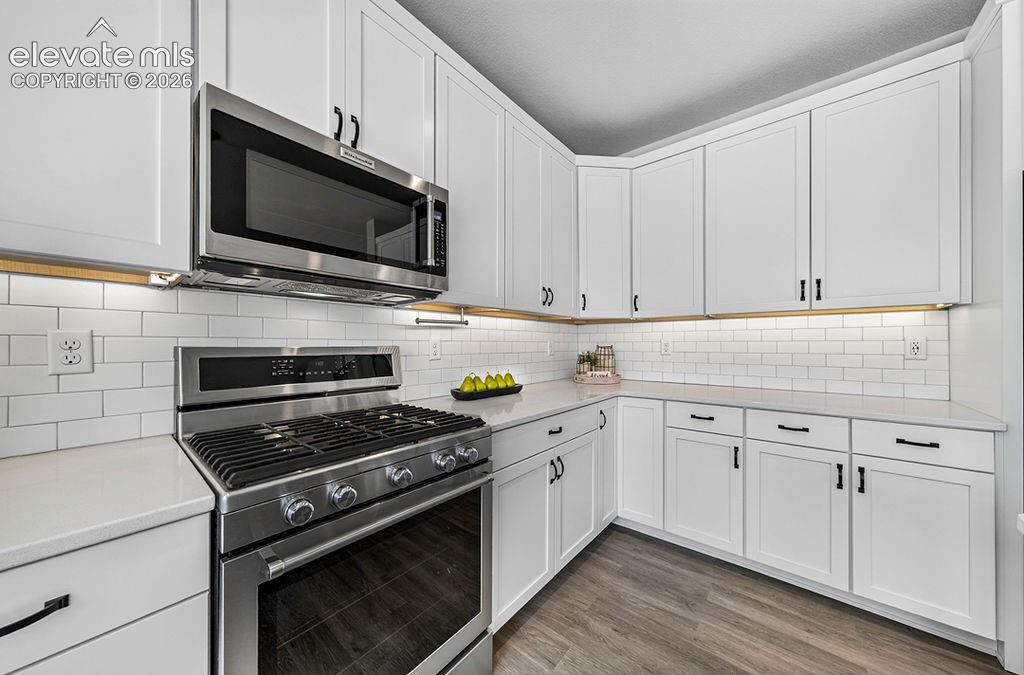 Image 20 of 47: Modern kitchen featuring white shaker cabinetry, stainless steel appliances