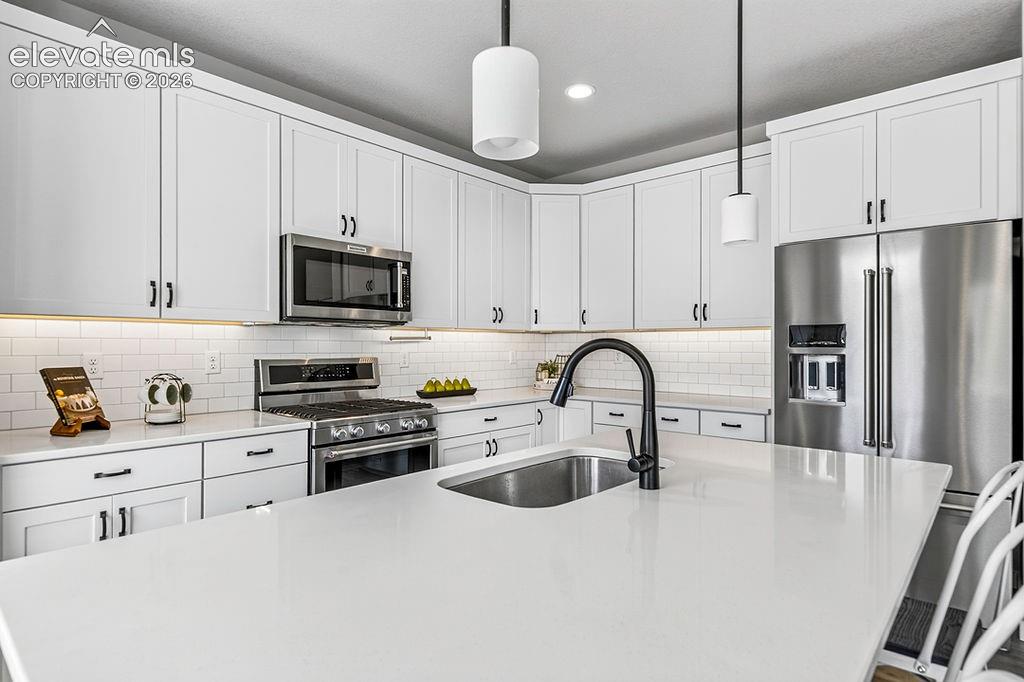 Image 21 of 47: Modern kitchen featuring an expansive island with an undermount sink and ma