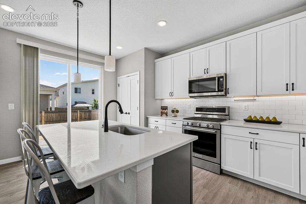 Image 22 of 47: Modern kitchen featuring a large center island with integrated sink, pendan