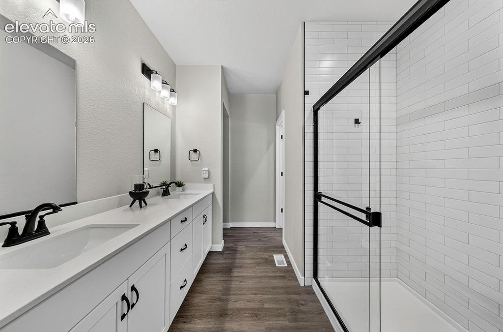 Image 27 of 47: Double vanity with white countertops, matte black faucets, and rectangular