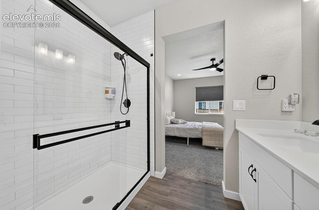 Image 30 of 47: Bathroom featuring a glass-enclosed shower with subway tile surround, matte