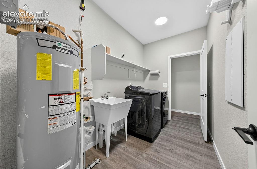 Image 33 of 47: Dedicated utility room featuring a utility sink, wall-mounted shelving, and