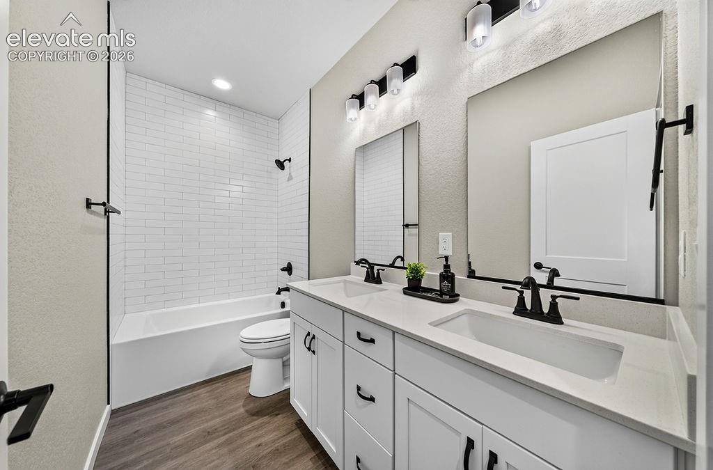 Image 35 of 47: Bathroom featuring a double vanity with white cabinetry and integrated sink