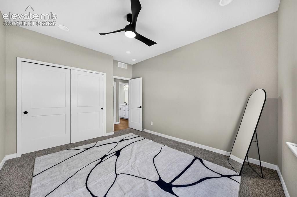 Image 38 of 47: Neutral tone walls with recessed lighting and a black ceiling fan
