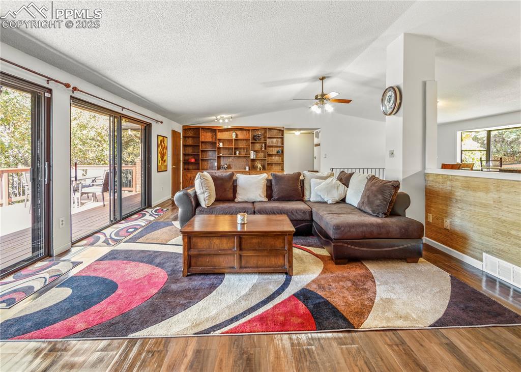 Image 3 of 33: Living room with lofted ceiling, wood finished floors, a textured ceiling, 