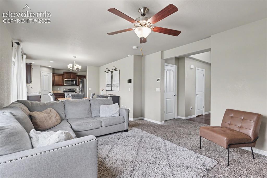 Image 10 of 40: Open-concept living area featuring a ceiling fan with integrated lighting,