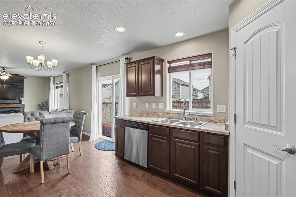 Image 15 of 40: Kitchen area featuring wood-finish flooring, dark wood cabinetry, a double