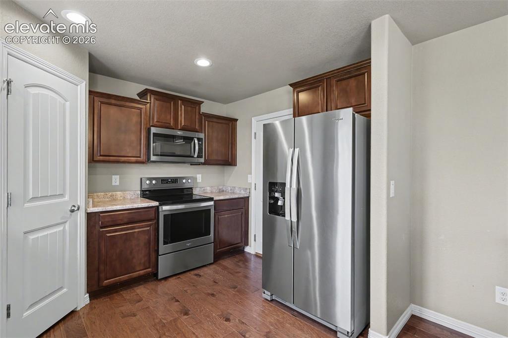 Image 17 of 40: Kitchen featuring wood-finish flooring, recessed lighting, and rich wood ca