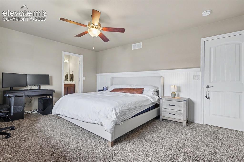 Image 19 of 40: Neutral-toned bedroom featuring a ceiling fan with integrated lighting, tex