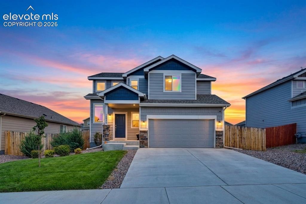 Image 2 of 40: Two-story residence featuring a gray exterior with blue accents, a two-car