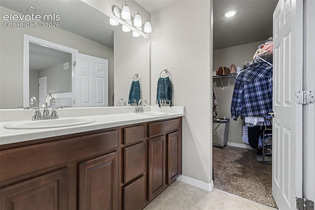 Image 21 of 40: Bathroom vanity featuring a dual sink design, polished chrome faucets, and