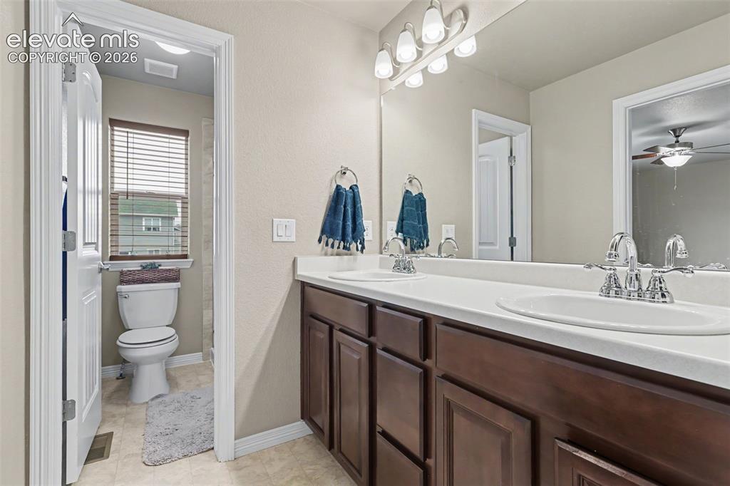 Image 22 of 40: Dual vanity with white countertop and integrated sinks, chrome fixtures, an