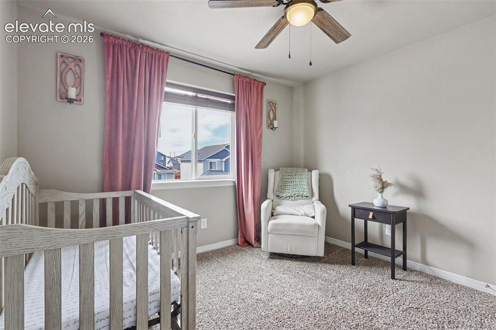 Image 24 of 40: Carpeted room featuring a ceiling fan with integrated lighting, a double-pa