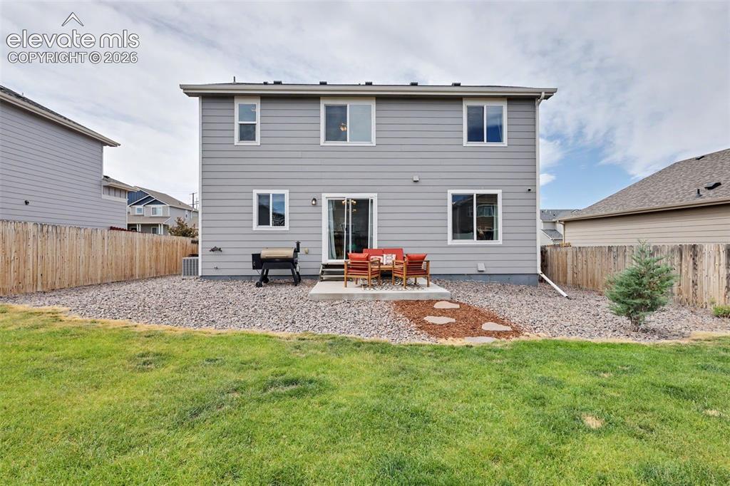 Image 31 of 40: Rear exterior featuring gray horizontal siding, a concrete patio, and a sli