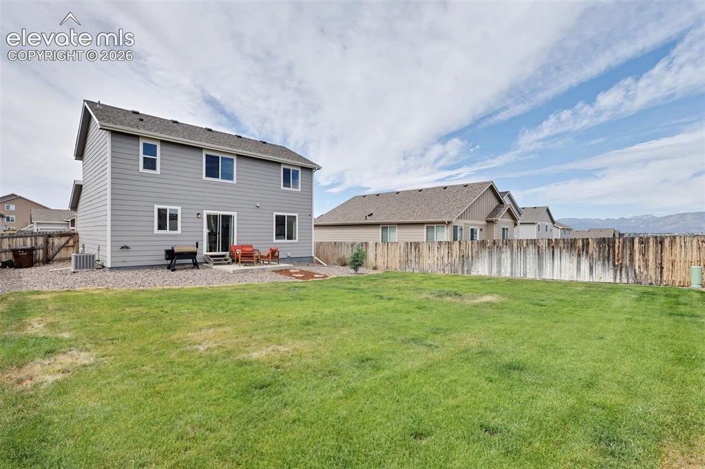 Image 32 of 40: Expansive grass yard with a full privacy fence
