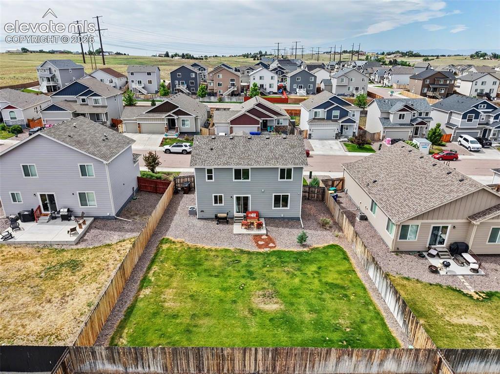 Image 33 of 40: Fenced backyard with a grassy lawn, complemented by a concrete patio for ou