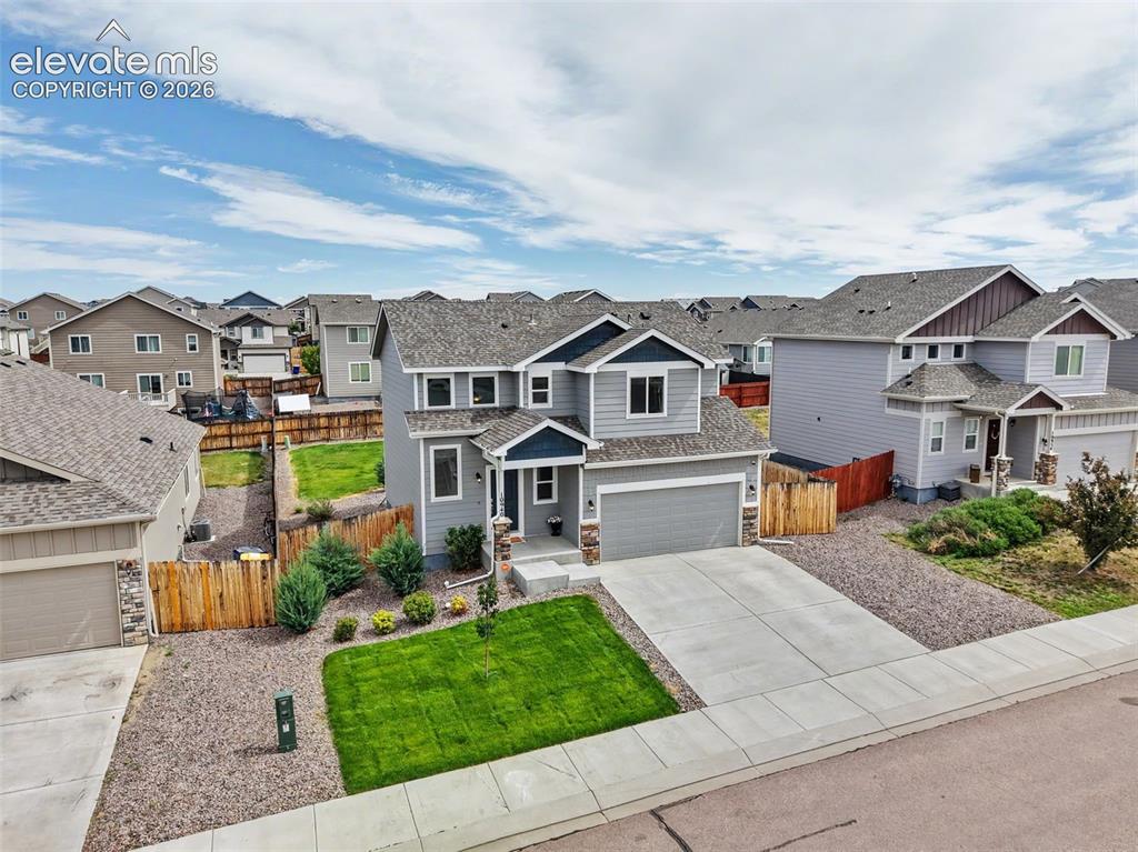 Image 37 of 40: Two-story residence featuring a two-car garage, stone accent siding, and a