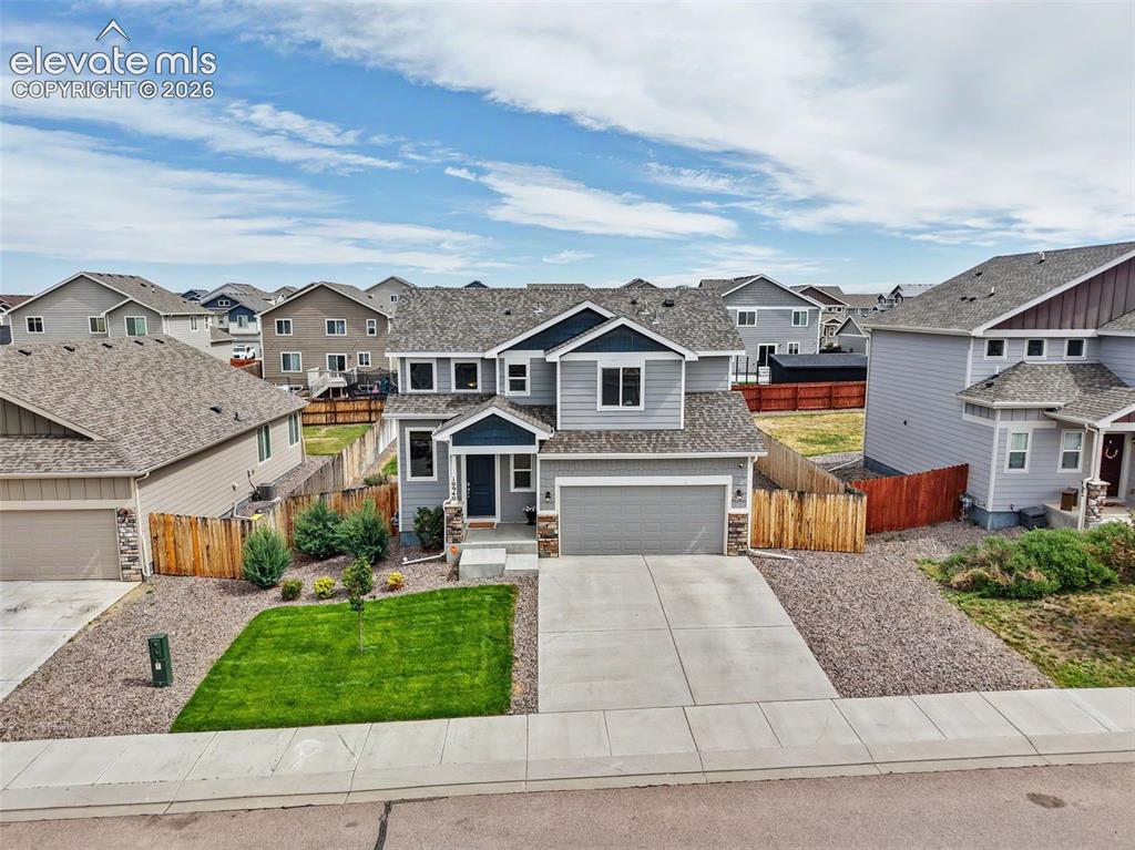 Image 38 of 40: Contemporary two-story residence featuring a gray exterior with blue accent