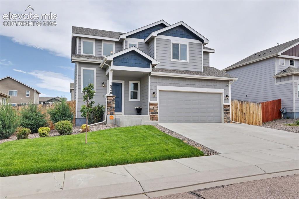 Image 5 of 40: Two-story home with a gray siding exterior and blue accent gables
