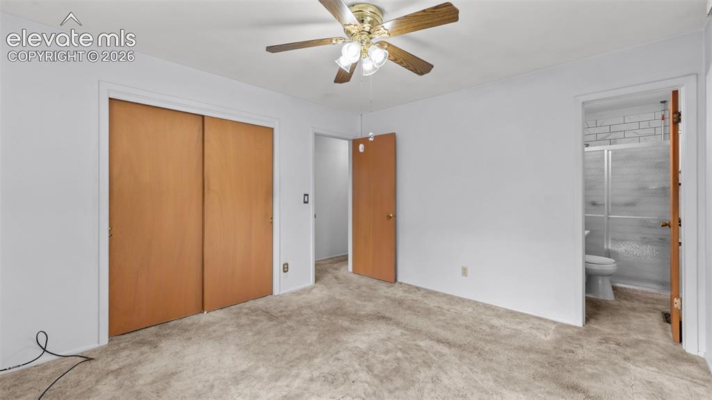 Image 14 of 36: Main level primary bedroom with en suite bath