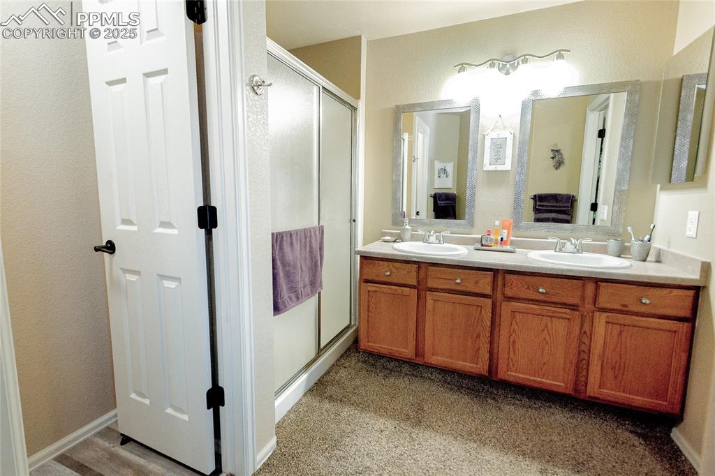 Image 17 of 33: Full bathroom featuring a stall shower, double vanity, and a sink