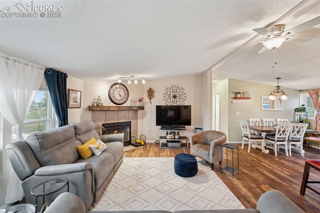 Image 17 of 33: Living area featuring LVT floors, a fireplace, a textured ceiling, and ceil