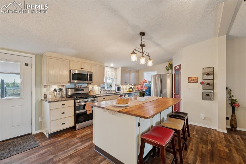 Image 20 of 33: Kitchen featuring backsplash, appliances with stainless steel finishes, dec