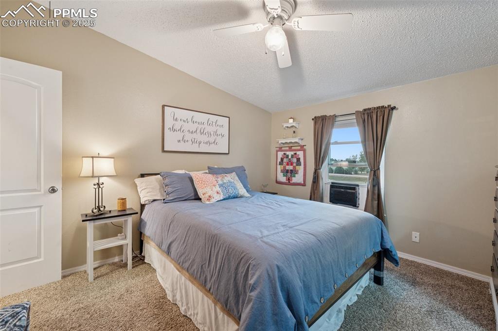 Image 30 of 33: Bedroom with carpet flooring, ceiling fan, and walk-in closet.