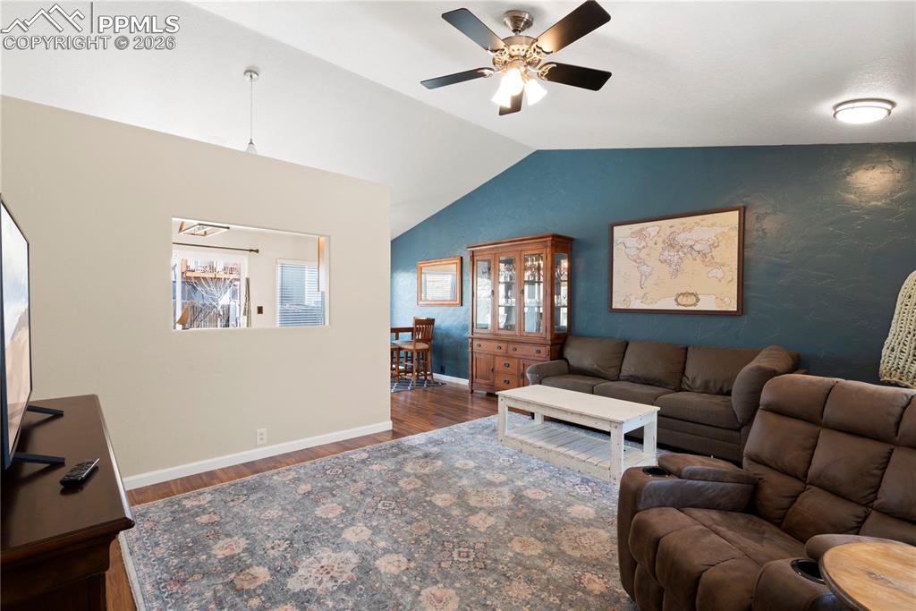 Image 10 of 27: Living room featuring dark wood-type flooring and ceiling fan