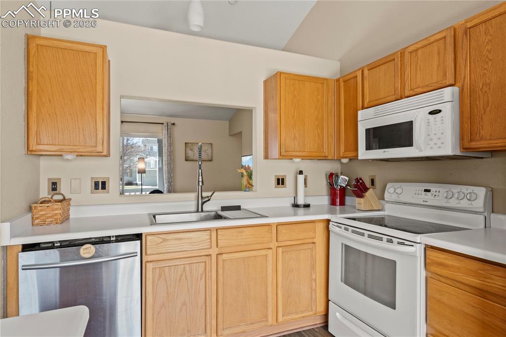 Image 15 of 27: Kitchen with white range with electric stovetop, light countertops, stainle