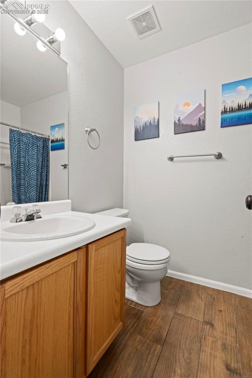 Image 17 of 27: Bathroom with vanity, a shower with curtain, and dark wood-style flooring