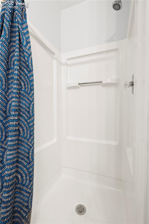 Image 18 of 27: Bathroom featuring a stall shower