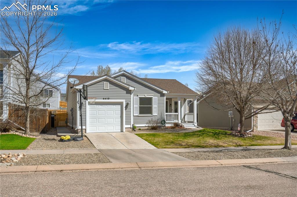 Image 2 of 27: View of front of property featuring a porch, driveway, and a garage