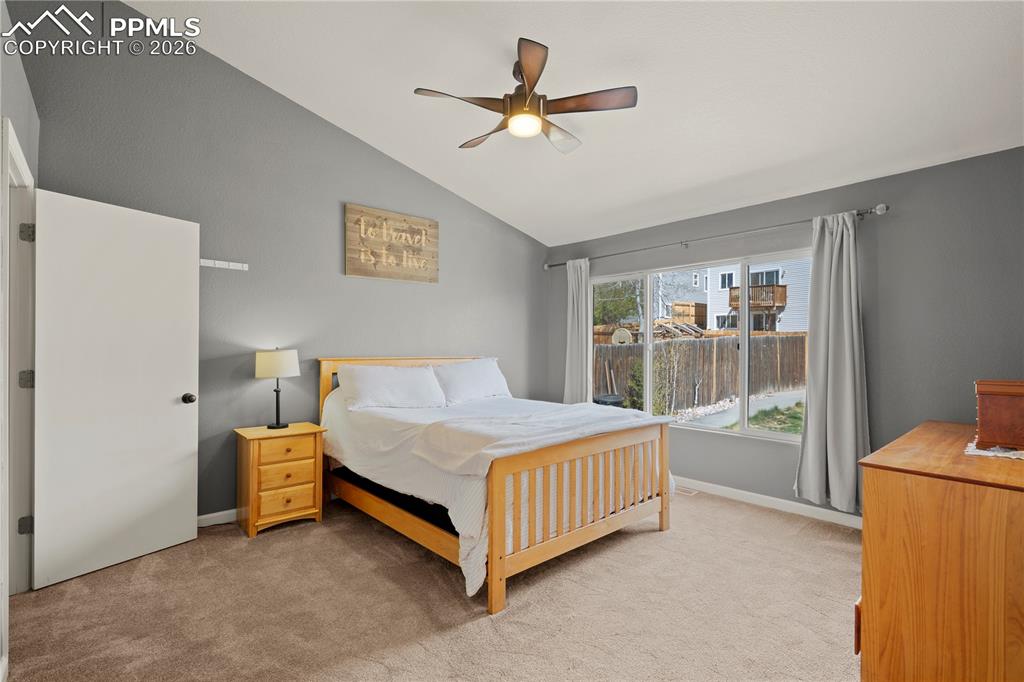 Image 20 of 27: Bedroom with light colored carpet, a ceiling fan, and lofted ceiling