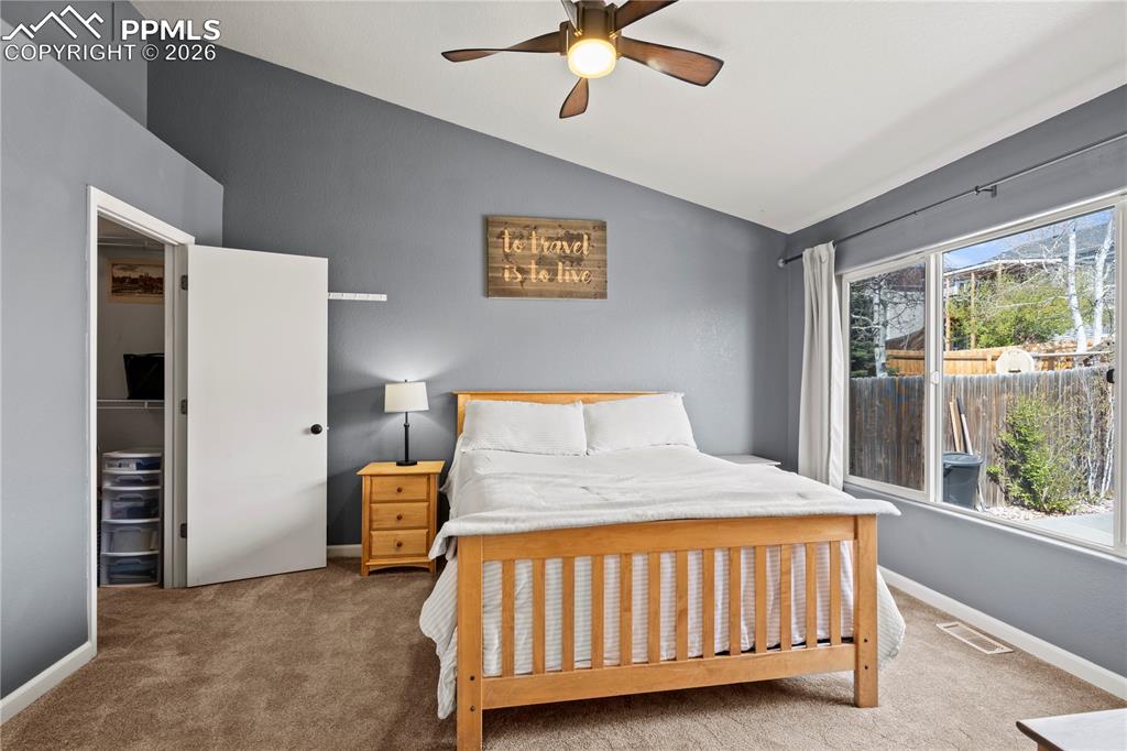 Image 21 of 27: Carpeted bedroom featuring lofted ceiling and ceiling fan