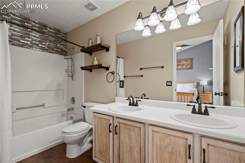 Image 25 of 27: Ensuite bathroom with double vanity, shower / bathtub combination with curt