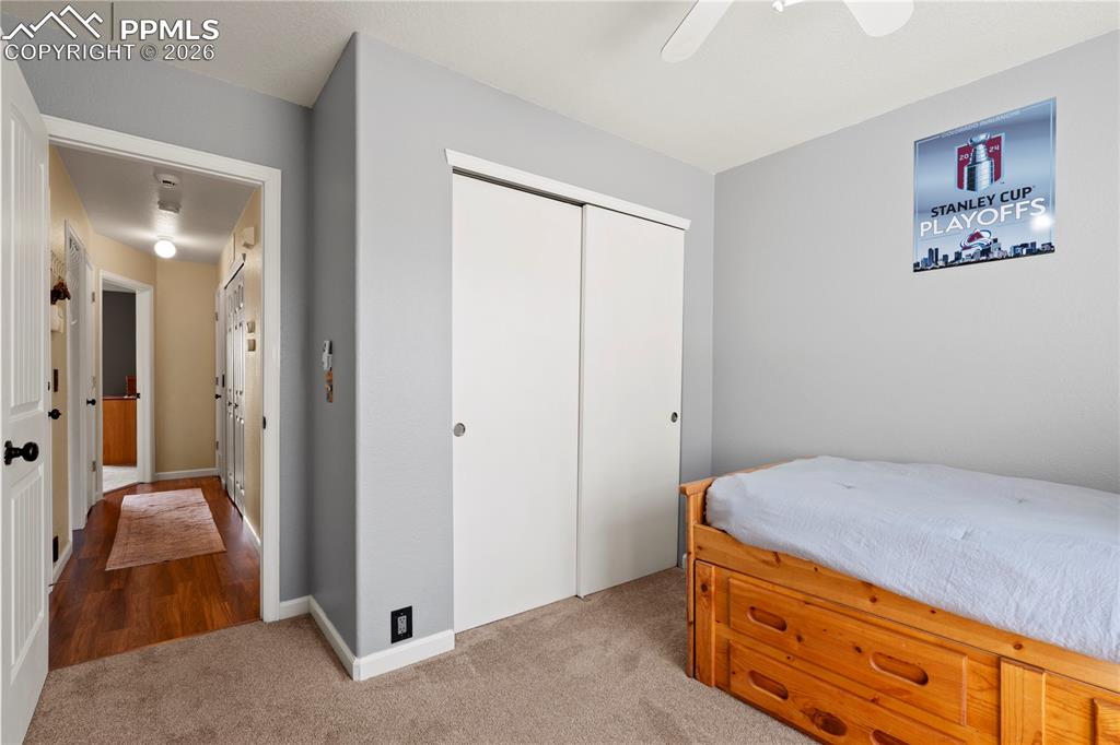 Image 27 of 27: Bedroom with light colored carpet, a closet, and a ceiling fan