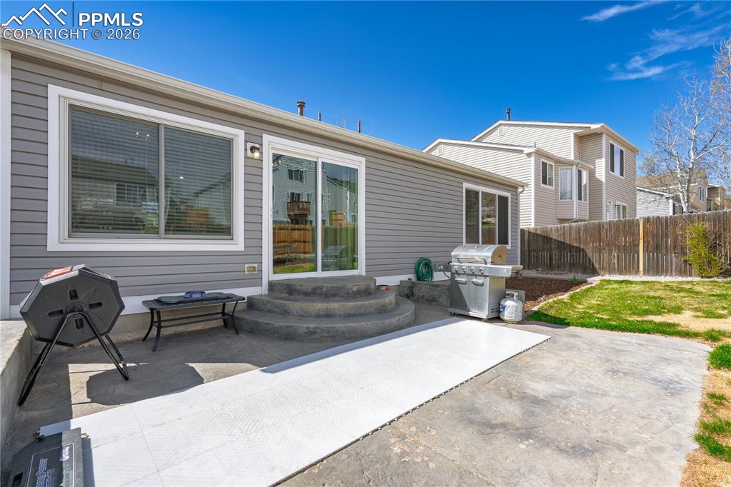 Image 7 of 27: Rear view of house with a patio and entry steps