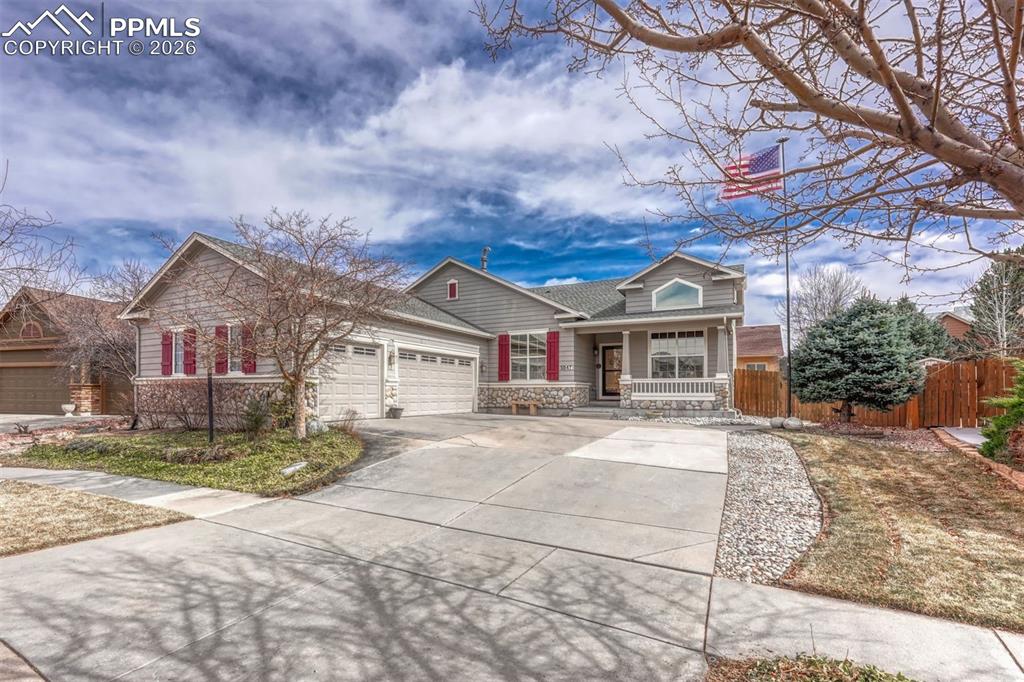 Image 1 of 45: View of front of house with stone siding, a porch, an attached garage, and 
