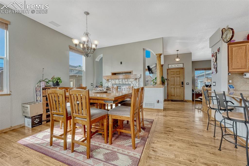 Image 11 of 45: Dining space with arched walkways, light wood finished floors, healthy amou