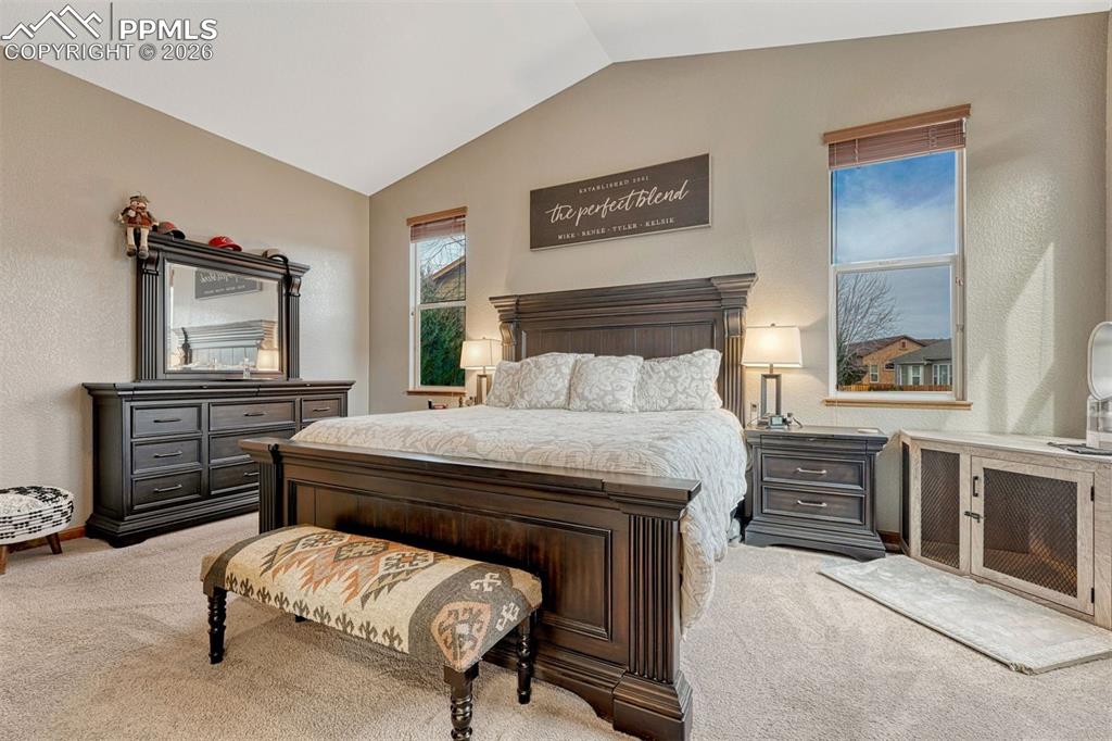 Image 14 of 45: Bedroom with carpet, vaulted ceiling, and  textured walls