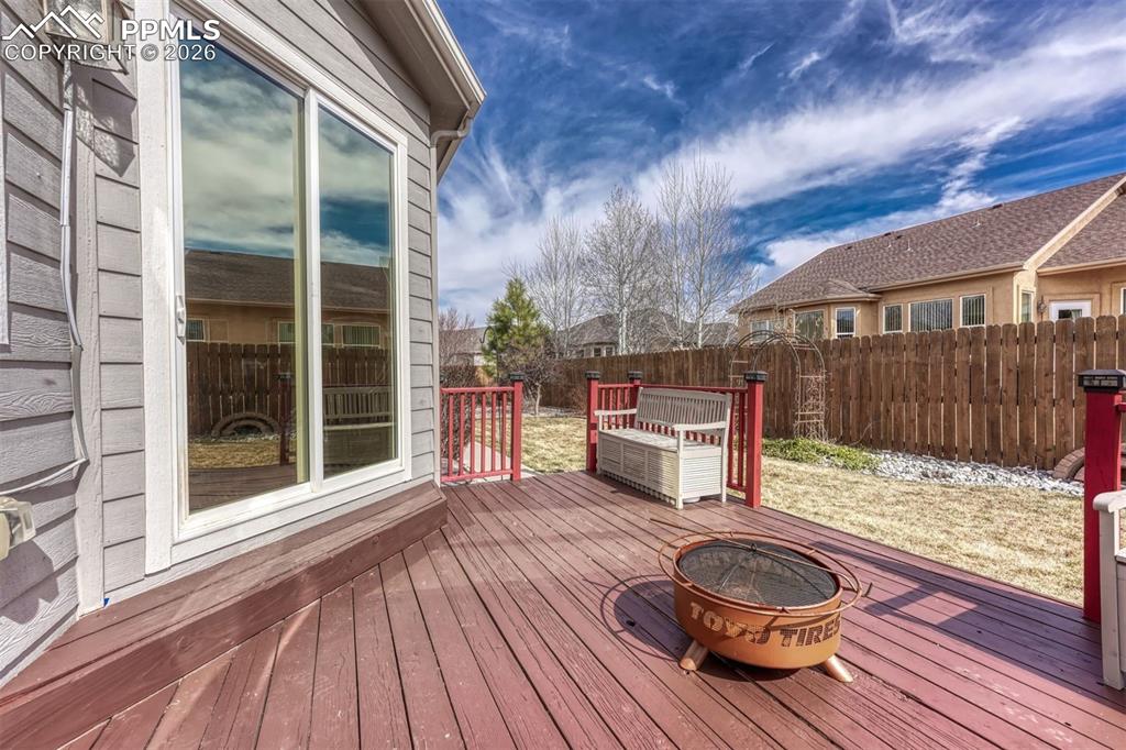 Image 23 of 45: Deck with an outdoor fire pit and a fenced backyard
