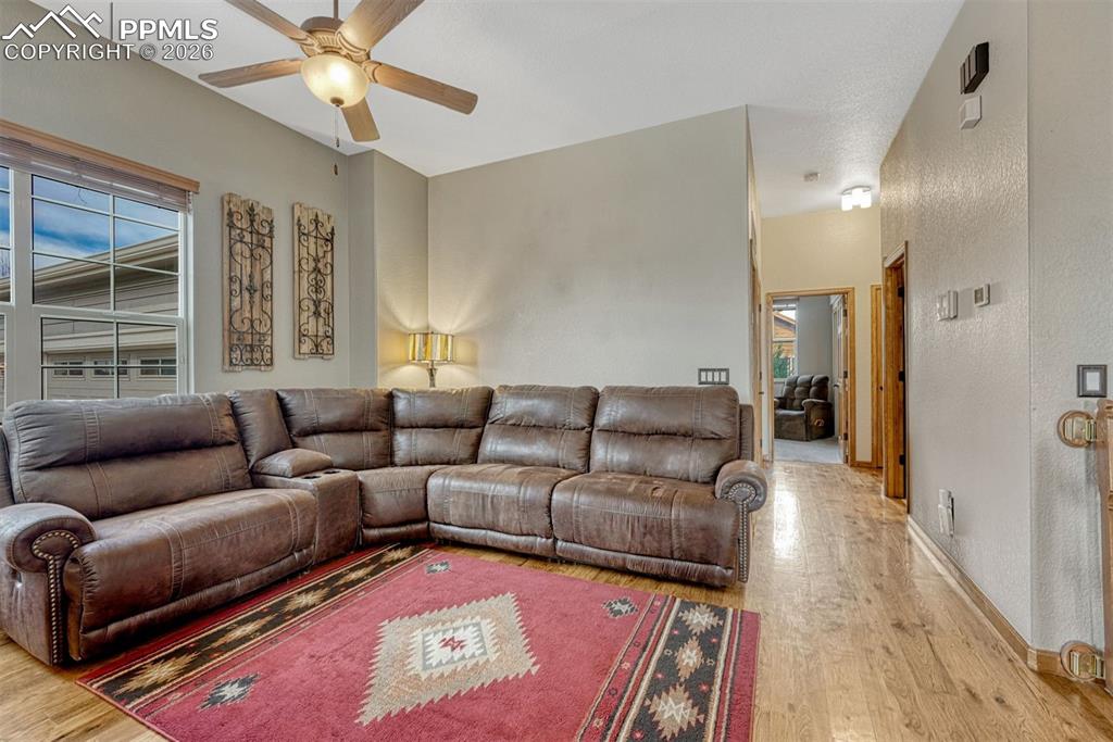 Image 7 of 45: Living area with wood floors and a ceiling fan