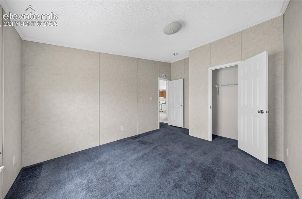 Image 12 of 41: Carpeted flooring, paneled walls, and a built-in closet