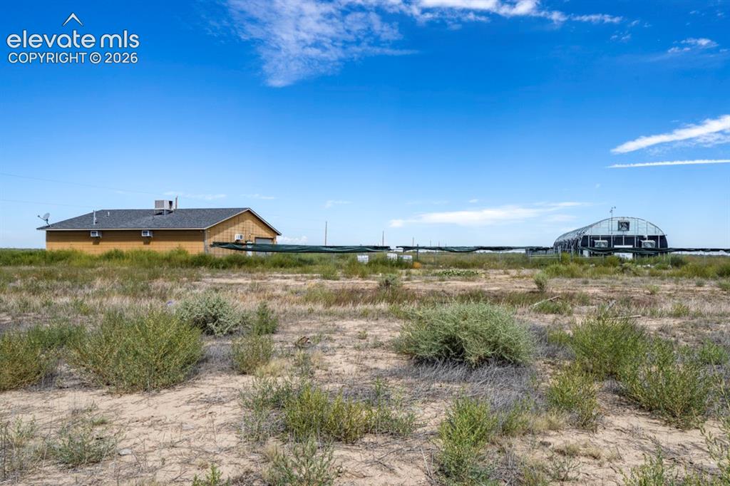 Image 23 of 41: Shop w/ Greenhouse, fencing, AC units, bay door, front and back door entran
