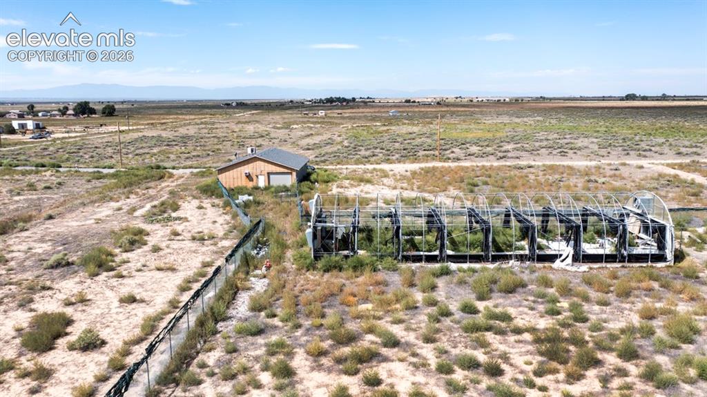 Image 30 of 41: Expansive open land featuring a shop with siding and an arched greenhouse