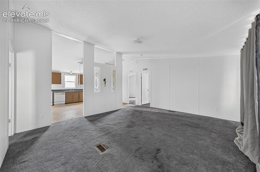 Image 6 of 41: Open-concept living area with carpeting