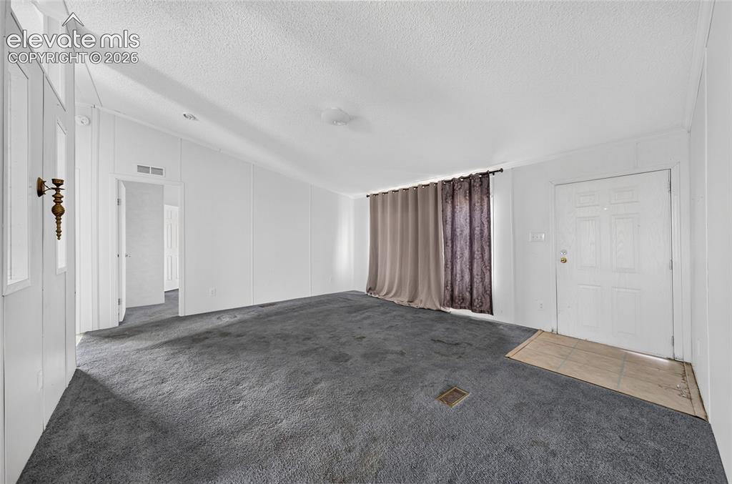 Image 7 of 41: Open-concept living area with carpeting